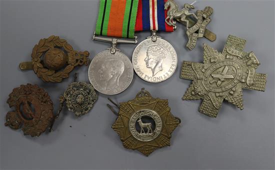 Two WWII service medals and six cap/tunic badges